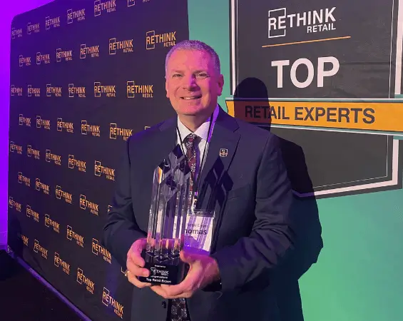man in a suit holding a trophy